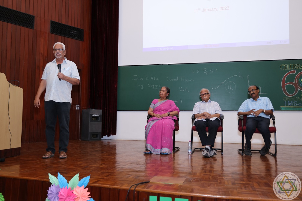 TR Govindarajan speaking at Bal-Fest. In the background are Bal (centre), his spouse Indra (left) and IMSc Director V Ravindran (right), January 2023.(Source: IMSc Archives)